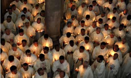 Catholic clergymen hold candles
