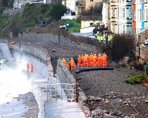 Engineers and members of the emergency services  survey the sunken section of the mainline railway track near Dawlish, Devon.