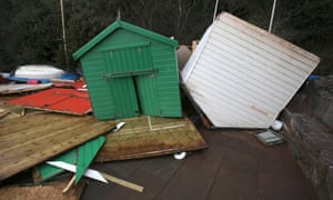 Beach huts are damaged by the storm waves at Dawlish.