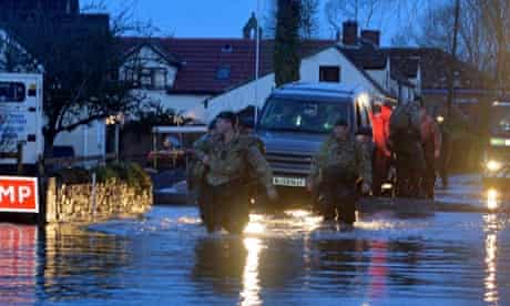 Royal Marines lead volunteers and fire services through Moorland on the Somerset Levels early on Friday