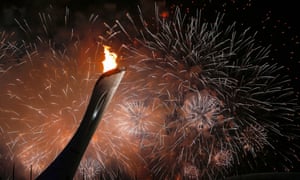 Fireworks light up the night sky as the Olympic flame is lit in the Olympic Cauldron.