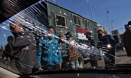 Egyptian security forces look at the shattered windscreen of a vehicle damaged in the Giza bombings