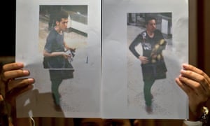 A Malaysian police official displays photographs of the two men who boarded the Malaysia Airlines MH370 flight using stolen European passports to the media at a hotel near Kuala Lumpur.