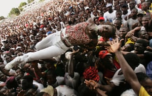 An unconscious woman is carried by supporters of Liberian presidential candidate George Weah after she fell ill from heat during a rally on October 8, 2005 in Monrovia, Liberia. Hundreds of thousands of people attended the rally for Weah, a former international soccer star, on a brutally hot day, with many reportedly collapsing from the heat.