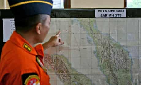 An Indonesian air force officer with map of Strait of Malacca in the search for the missing plane