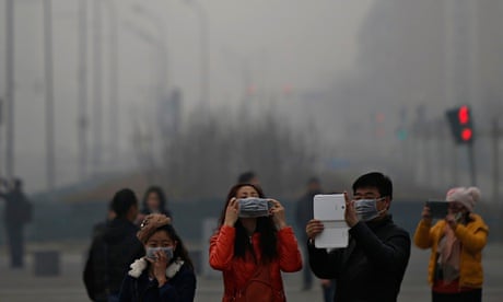 A woman adjusts her mask amid thick haze in Beijing