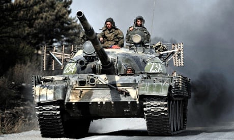 Russian soldiers on top of a tank drive on a road near the flashpoint city of Gori on 18 August 2008
