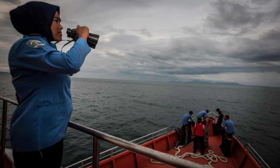 A member of the Indonesian search team uses binoculars to look for flight MH370 in the Andaman Sea, near the northern tip of Sumatra island.