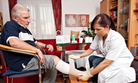 Nurse bandages an elderly man's leg