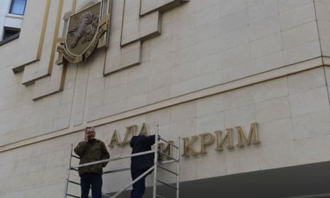 Workers dismantle the Ukrainian signs on Crimean Parliament building on March 18, 2014 in Simferopol, Ukraine. 