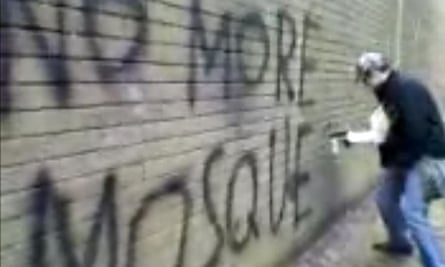 Still image from video seen by jury shows Michael Piggin writing anti-Muslim graffiti on a wall
