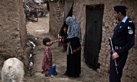 A Pakistani health worker marks the finger of a child after giving her a polio vaccine