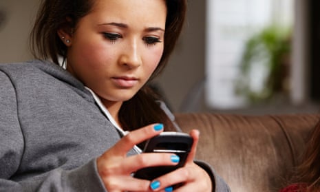Teenage girl looking at cellphone cyber bullying