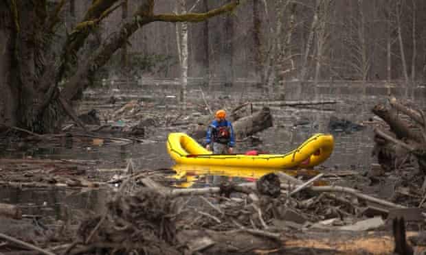 A man in a search and rescue boat floats through the debris after the mudslide near Oso, Washington.