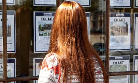 Woman looks into the window of an estate agent