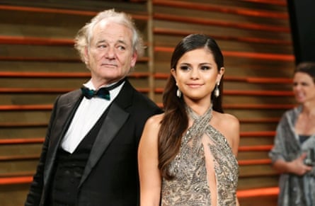Actor Bill Murray "photobombs" singer Selena Gomez as they arrive for the 2014 Vanity Fair Oscars Party