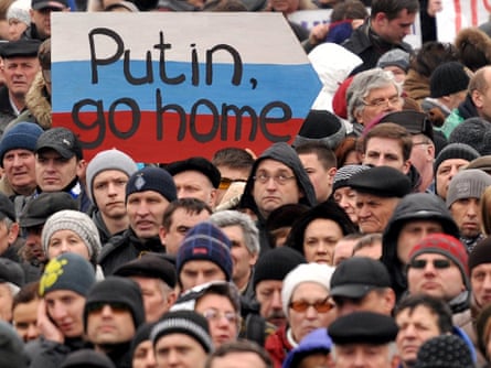 A man holds a sign against Putin as 30,000 people rally in the Independence Square
