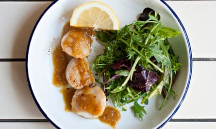 Tree crinan scallops drizzled with curry butter next to salad