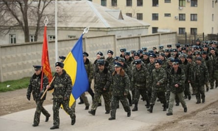 Unarmed Ukrainian troops bearing their regiment and the Ukrainian flags march to confront soldiers under Russian command occupying the Belbek airbase in Crimea in Lubimovka, Ukraine.
