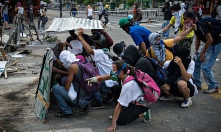 Demonstrators using improvised shields to protect from tear gas canisters and buckshot in Caracas