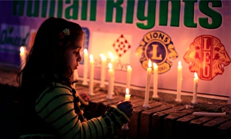 A girl lights candles during a rally to commemorate International Women's Day in Islamabad