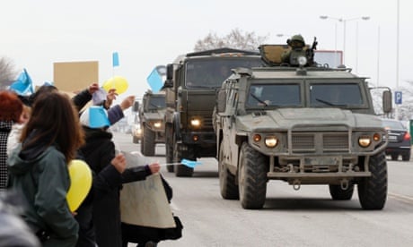 A Russian military convoy drives past pro-Ukraine protesters during a rally on a road in Simferopol, Crimea.