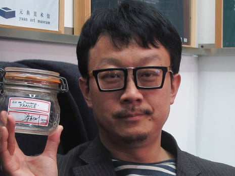 Beijing artist Liang Kegang poses with the jar of fresh air collected in Provence, France, in an art gallery in Beijing, China. The jar of air has fetched $860
