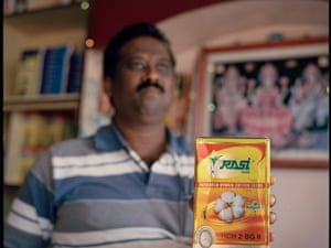 A shopkeeper in Yavatmal, Maharashtra, India, holding up a box of GM Bollgard cottonseeds.