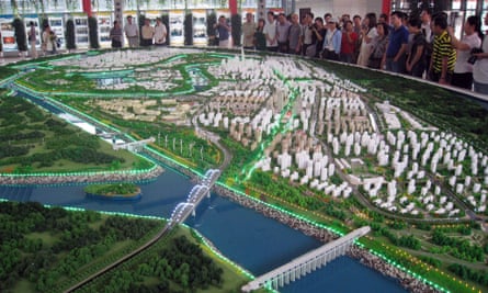 Visitors look at a model of Tianjin's eco-city. Once finished it will cover 30 km sq and house 350,000 people.