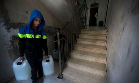 A boy carries water to his house in Shuafat. 