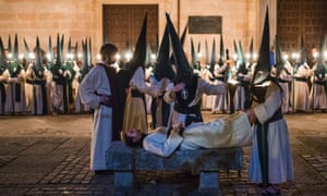 The 'Las Siete Palabras' brotherhood attend to a fellow penitent during a procession in Zamora, Spain.