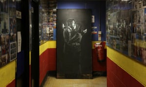 The latest officially confirmed Banksy artwork, named Mobile Lovers, featuring a man and a woman embraced and looking at their mobile phones, sprayed onto a black wooden board is displayed inside the Broad Plain & Riverside Youth Project in Bristol, England. The artwork, which comes days after a piece depicting three 1950s-style agents listening in on conversations in a telephone box appeared in Cheltenham, Gloucestershire, was originally attached to a blocked off doorway on Clement Street,  in the underground guerrilla street artist's hometown of Bristol. However, it was moved yesterday by members of the financially stricken youth club, who hope to auction the artwork to help raise funds for their struggling centre.