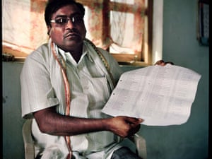 Vinod Kale, the head of Kalamb village holds up a list of all the cotton farmers who have commit suicide in his village