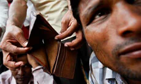 A migrant worker from Bangladesh shows his empty wallet to the camera in Singapore