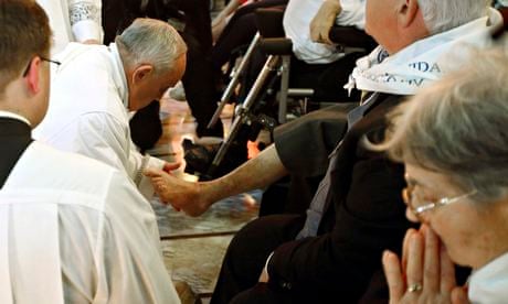 Pope Francis kneels to wash the foot of a man in a pre-Easter ritual