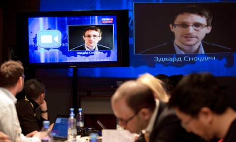 Edward Snowden appears on television screens as he questions Vladimir Putin.