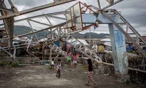 Children play under a damaged basketball hoop in Tacloban, Leyte, Philippines.