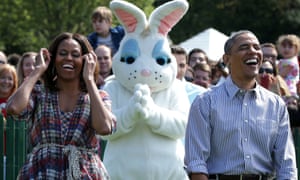 resident Barack Obama (R) and first lady Michelle Obama (L) rejoice as they watch children participate in the annual White House Easter Egg Roll 