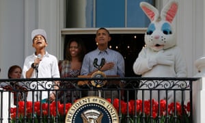 President Barack Obama (2nd R) and first lady Michelle Obama (2nd L) listen as Cam Anthony (L) sings the national anthem at the annual White House Easter Egg Roll 