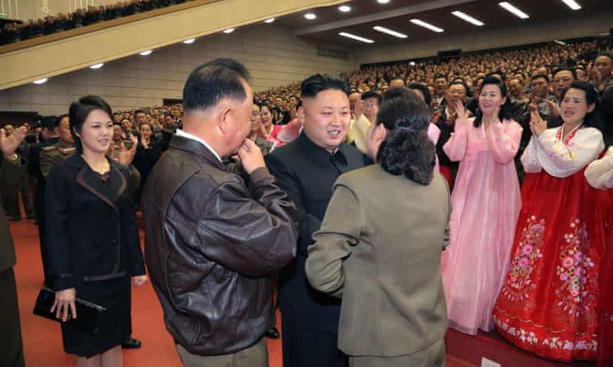 This photo released from North Korea's official Korean Central News Agency (KCNA) on April 20, 2014 shows Kim Jong-Un (C) speaking with the family of a military pilot at a performance given by the Moranbong Band