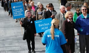 A demonstrator wearing a mask depicting Barclays Chief Executive Antony Jenkins in the shareholder queue.