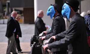Protesters wearing masks of the eagle emblem of Barclay's Bank stage a demonstration.