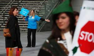 A guide directs shareholders to the Barclays AGM as protestors demonstrate.