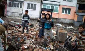 Roma children play while they salvage materials from a demolished shack in Plovdiv, Bulgaria.