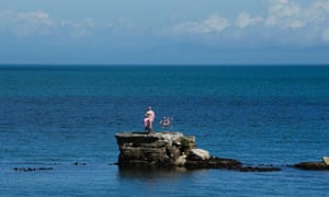 A model of a pink fisherman and bicycle are positioned on a rock in the Irish Sea to welcome the arrival of the Giro d'Italia cycle race.