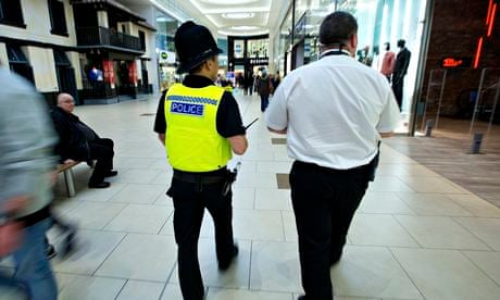 Police officer and security operative patrol a shopping centre 