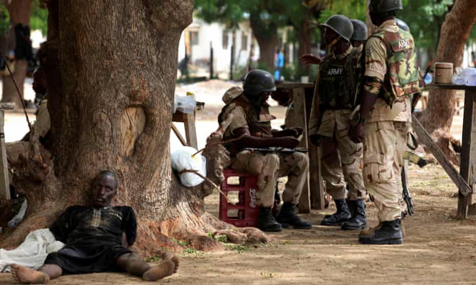 Suspected Islamist sect member captured by Nigerian troops as he lies next to a tree in Maiduguri, Nigeria.
