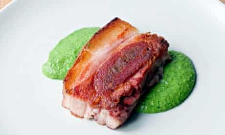 At Artusi a slab of pig's head sitting on salsa verde on a plate