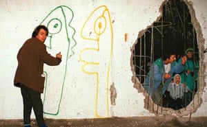 Thierry Noir paints the other side of the Berlin wall, reached through a hole.
