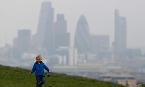 A boy plays as a haze of pollution sits over the London skyline. The pollution is expected to clear on Friday